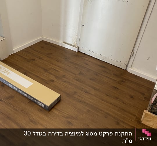 רצפת פרקט עץ כהה עם קופסת פרקט על הרצפה